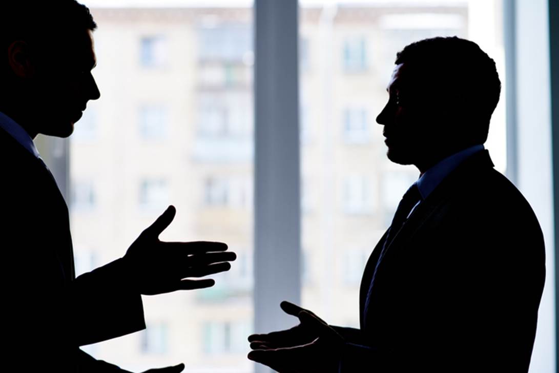A silhouette of men talking
AI-generated content may be incorrect.